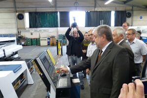 Kurt Beck drückt den Startknopf zur Inbetriebnahme