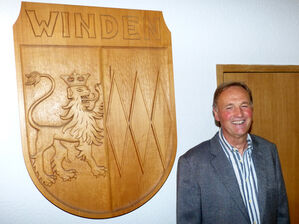 Der neue Bürgermeister vor dem Ortswappen